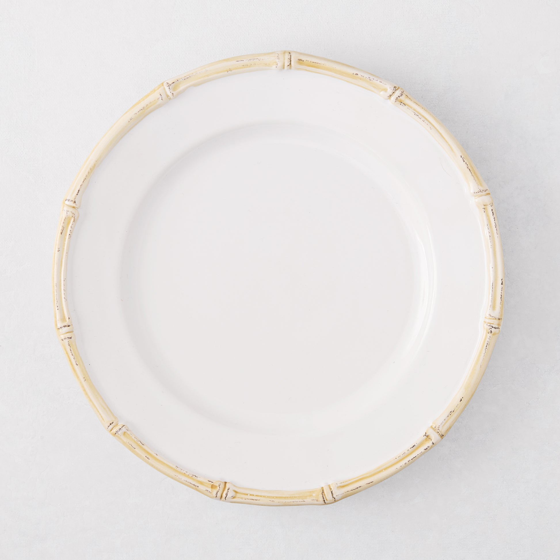 White ceramic salad plate with a natural-edged, bamboo-molded rim.