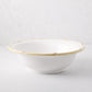 White ceramic serve bowl with a natural edge bamboo-style rim.