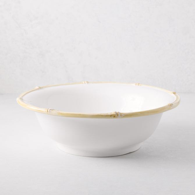 White ceramic serve bowl with a natural edge bamboo-style rim.