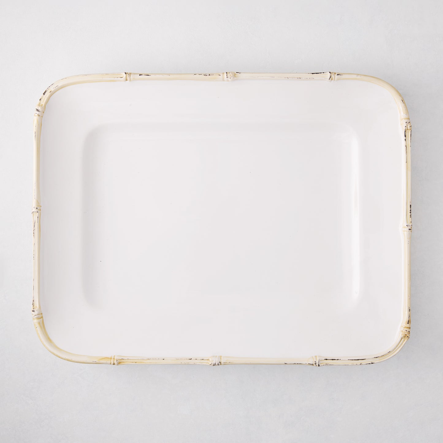 White rectangular ceramic serving platter with a natural-edge bamboo-molded rim.