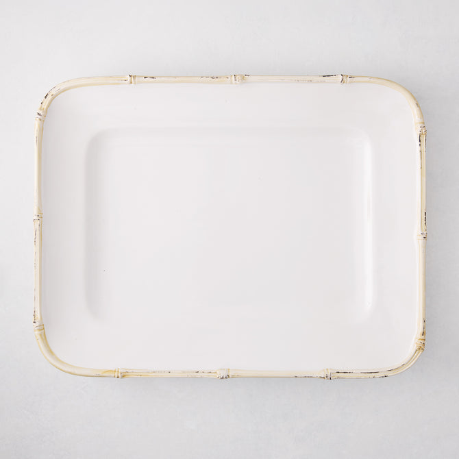 White rectangular ceramic serving platter with a natural-edge bamboo-molded rim.