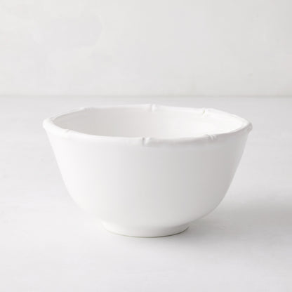 White ceramic cereal bowl with molded bamboo detailing on the rim.