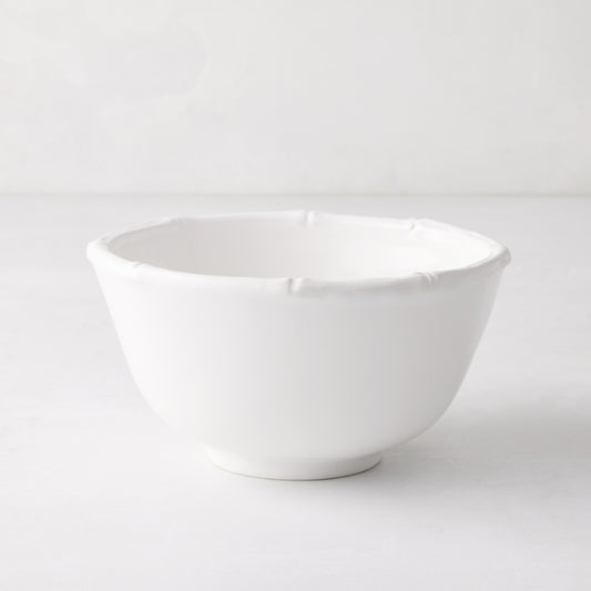 White ceramic cereal bowl with molded bamboo detailing on the rim.