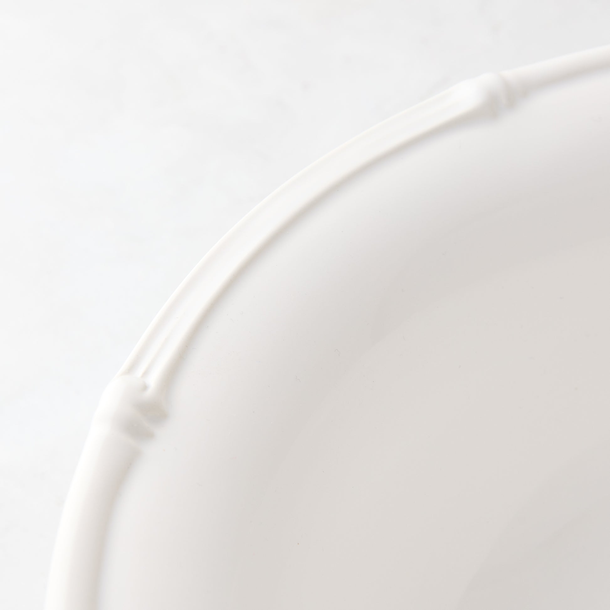 White ceramic dinner plate with a molded bamboo-style rim, 11" diameter.