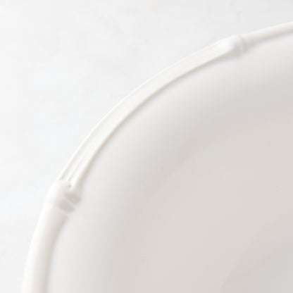 White ceramic dinner plate with a molded bamboo-style rim, 11" diameter.