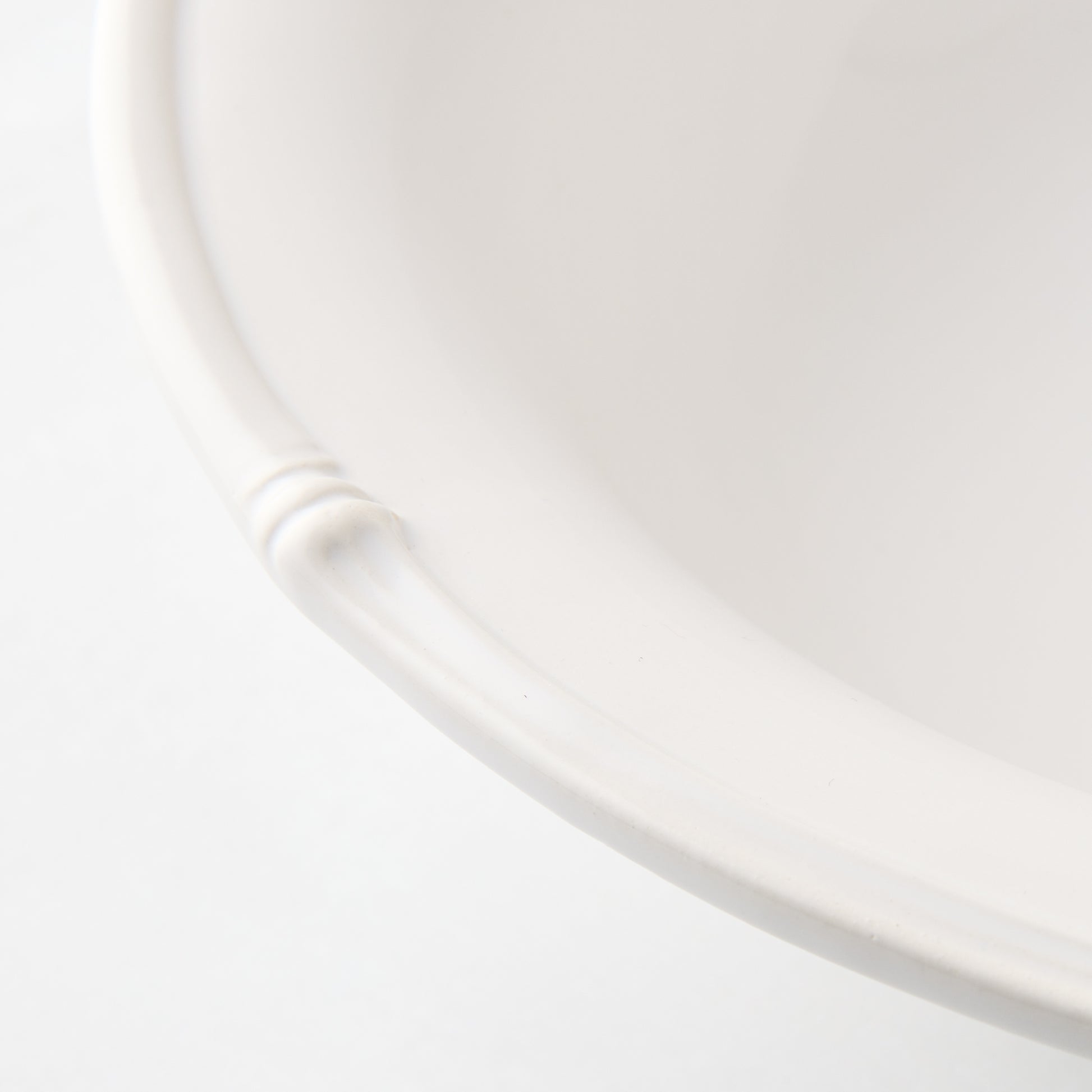 White ceramic nut bowl with molded bamboo detailing on the rim.