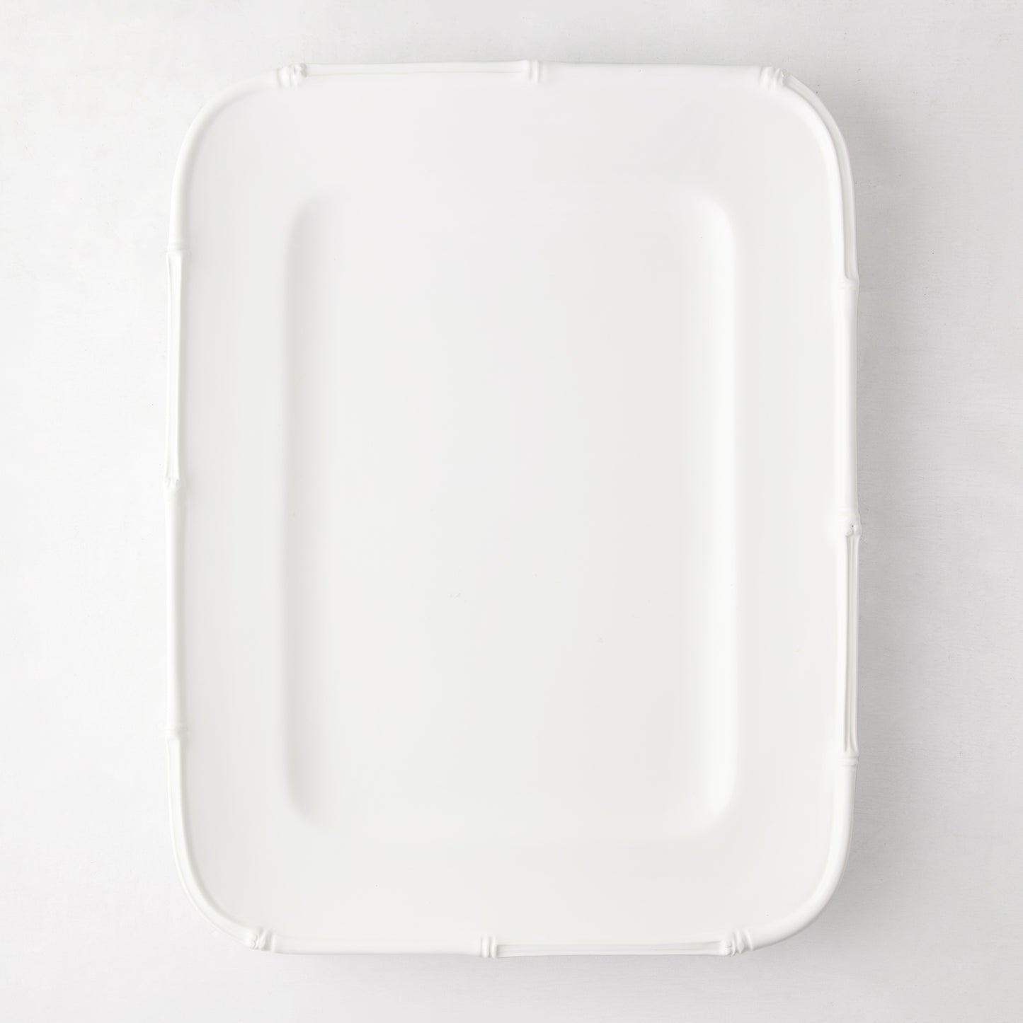 White ceramic rectangular serving platter with a molded bamboo-style edge, 17"L x 13"W.