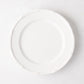 White ceramic salad plate with molded bamboo detailing on the rim.
