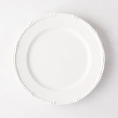 White ceramic salad plate with molded bamboo detailing on the rim.