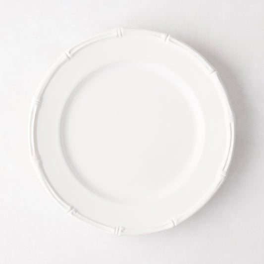 White ceramic salad plate with molded bamboo detailing on the rim.