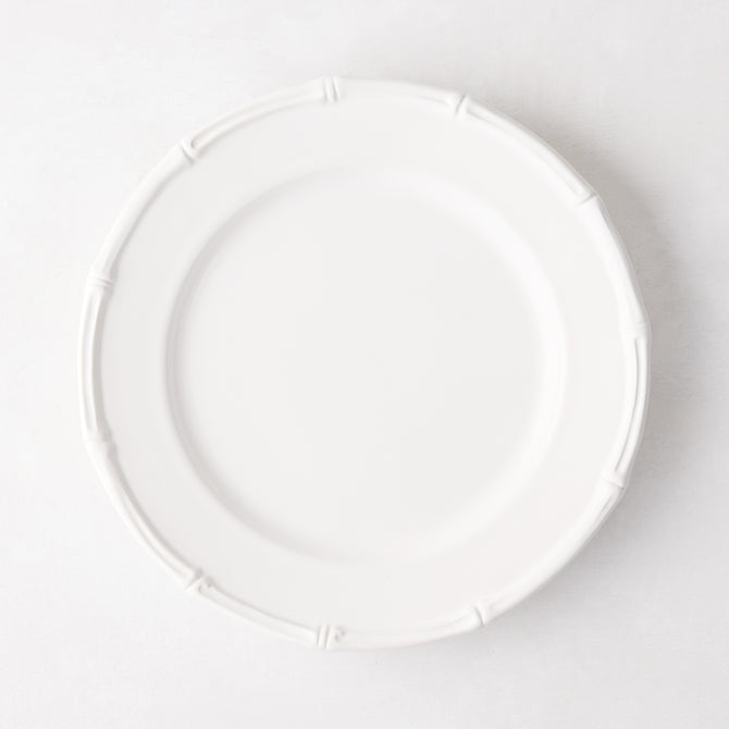 White ceramic salad plate with molded bamboo detailing on the rim.