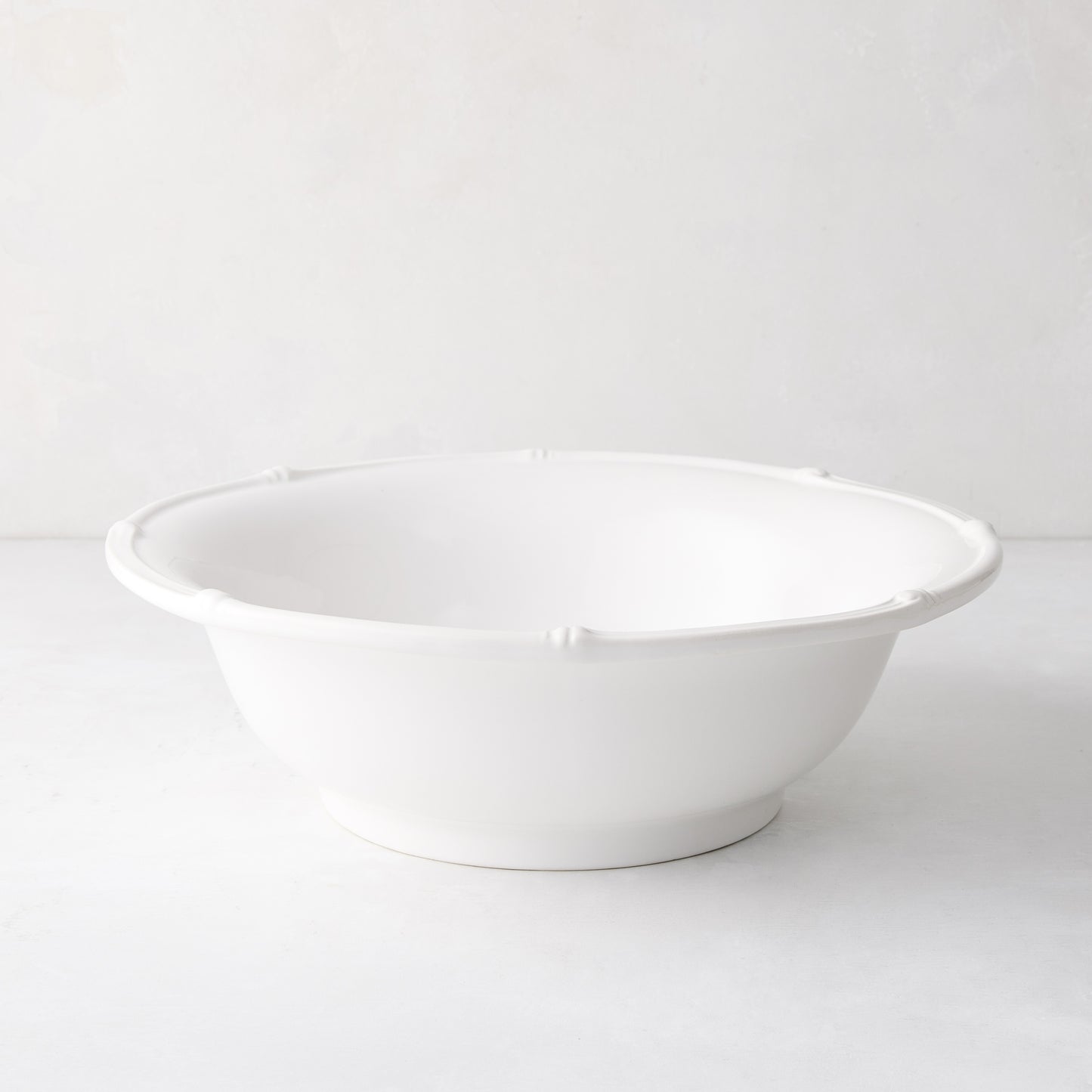 White ceramic serve bowl with molded bamboo detailing, 12" diameter.