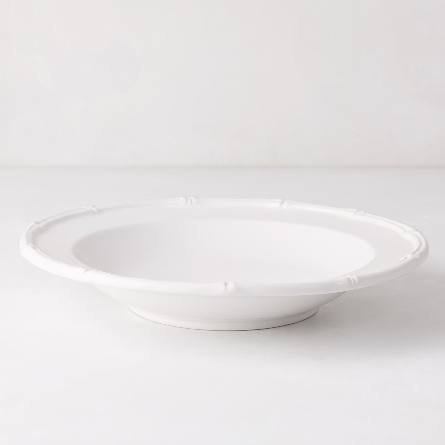 White ceramic soup bowl with molded bamboo detailing, 9.5" diameter.