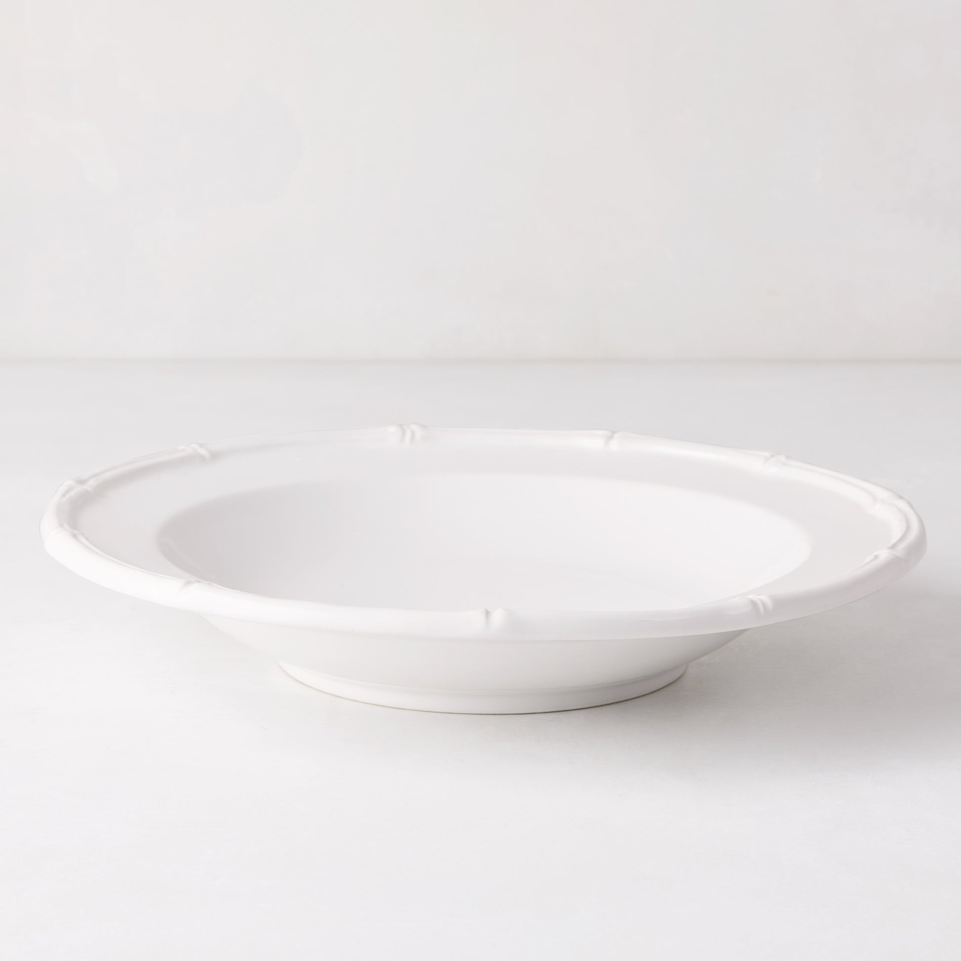 White ceramic soup bowl with molded bamboo detailing, 9.5" diameter.