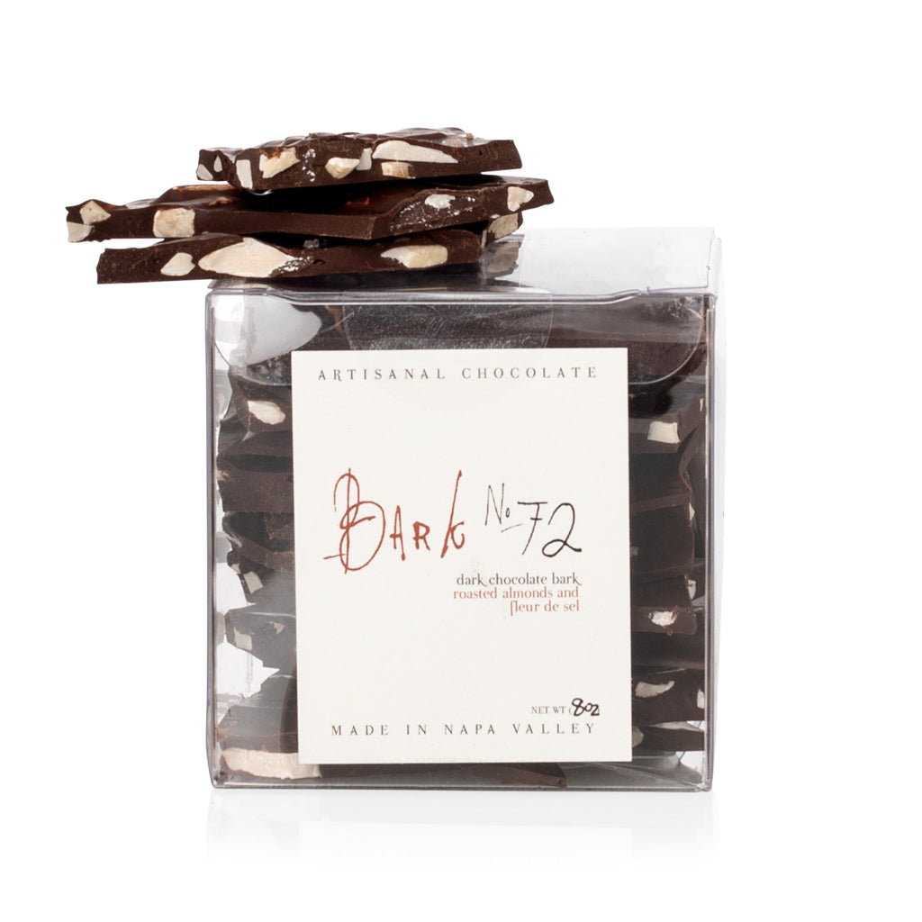 Bark No. 72 Dark Chocolate Almond Bark in clear 8oz box, with pieces stacked on top.