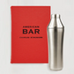 Red cloth-bound "American Bar" book and a silver stainless steel Craft Cocktail Shaker.