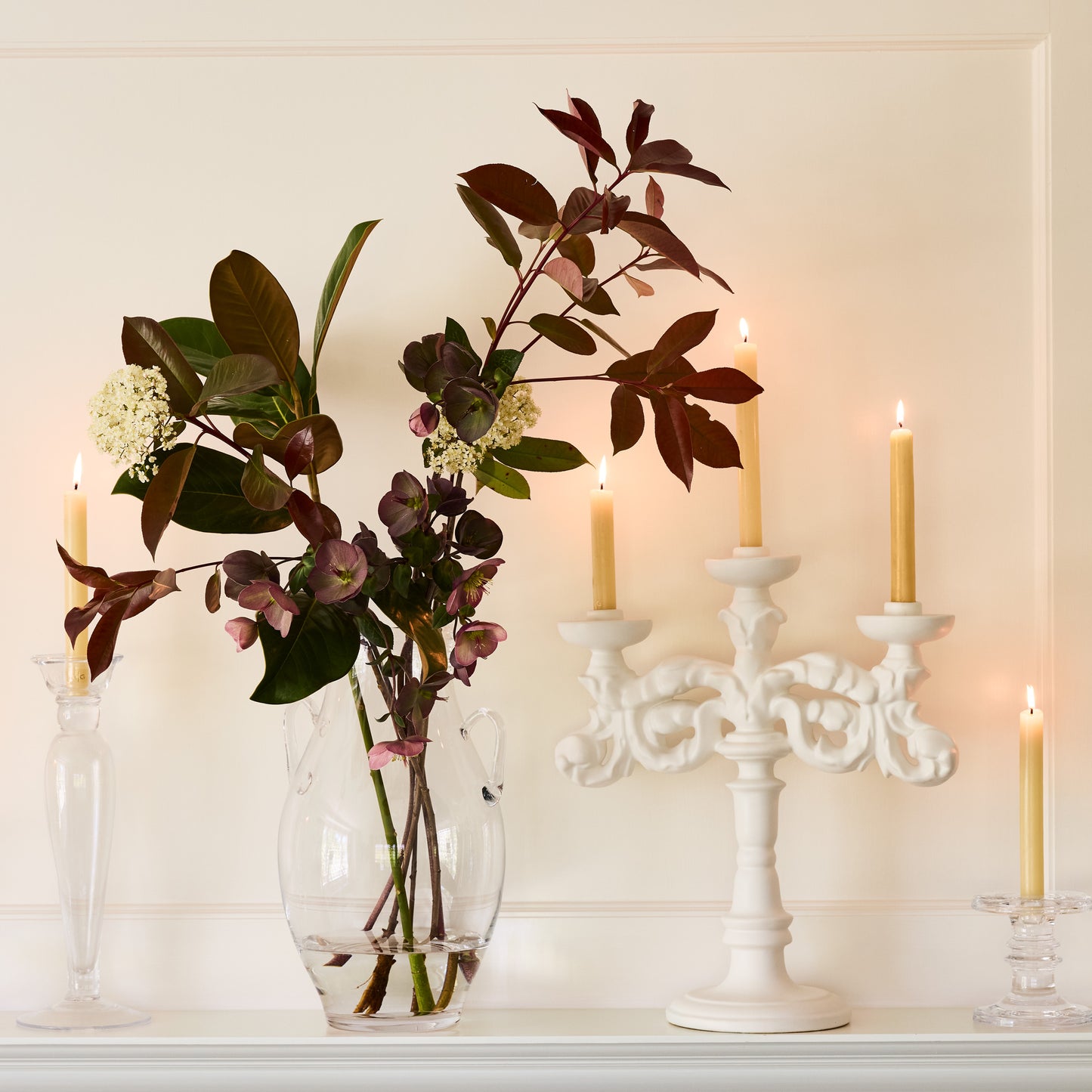 Baroque Matte White Ceramic Candelabra, 18"H, with intricate scrollwork and four lit taper candles.