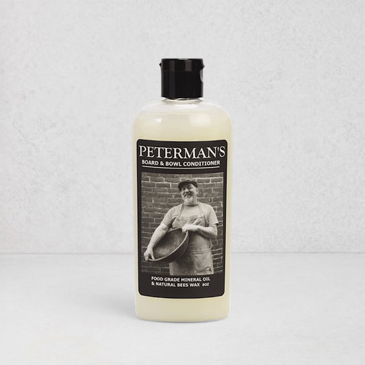 Peterman's 8oz Beeswax Conditioner for Wood Boards & Bowls, light bottle with black label featuring a man.