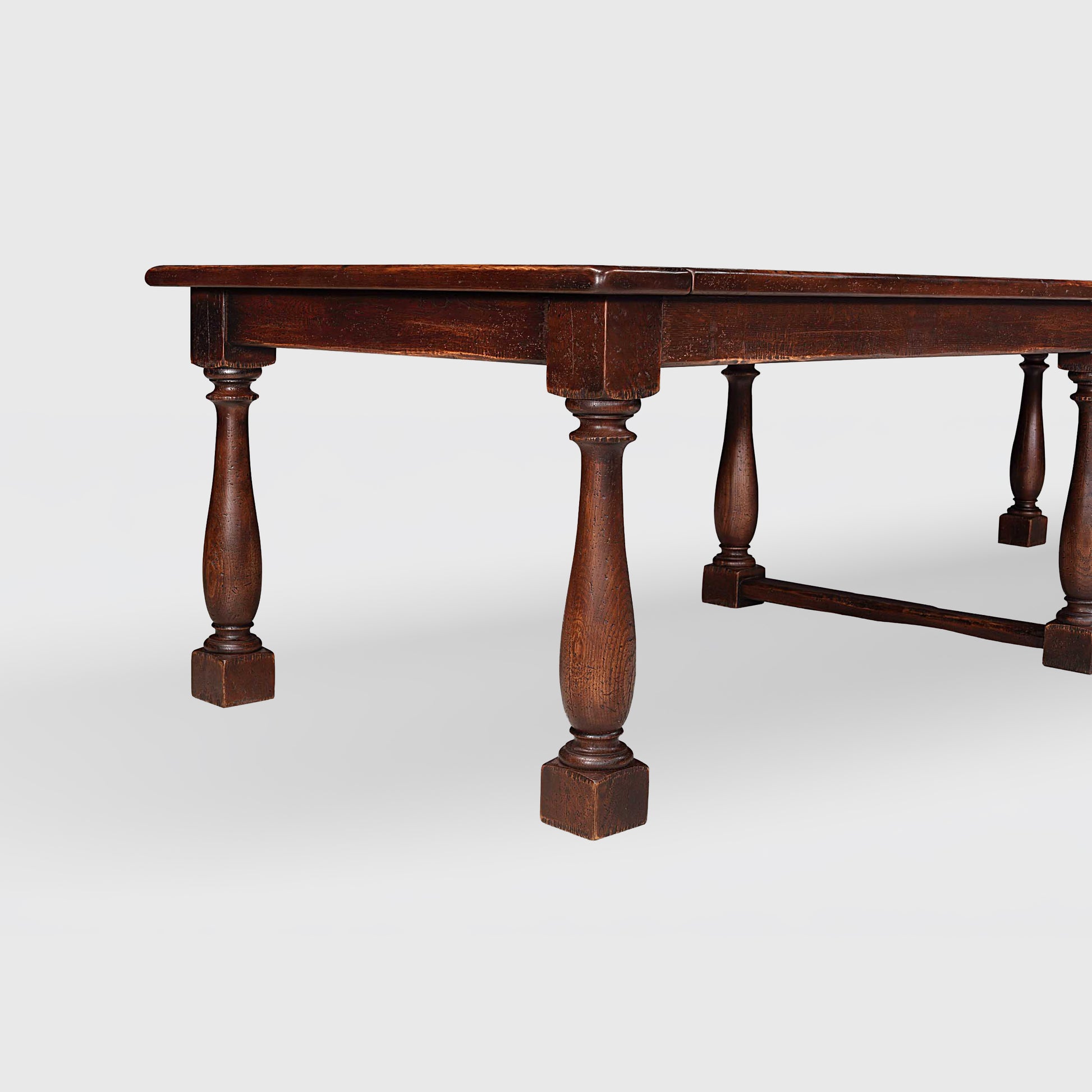 Benedictine extendable oak dining table in mahogany color with vintage patina and turned legs.