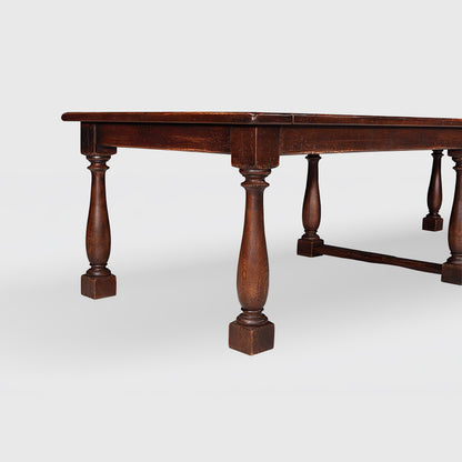 Benedictine extendable oak dining table in mahogany color with vintage patina and turned legs.