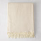 Birch off-white Italian herringbone throw blanket, folded, with fringe.