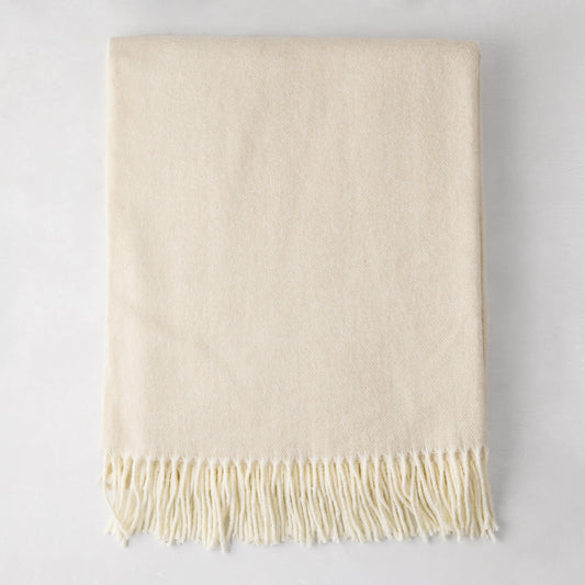 Birch off-white Italian herringbone throw blanket, folded, with fringe.