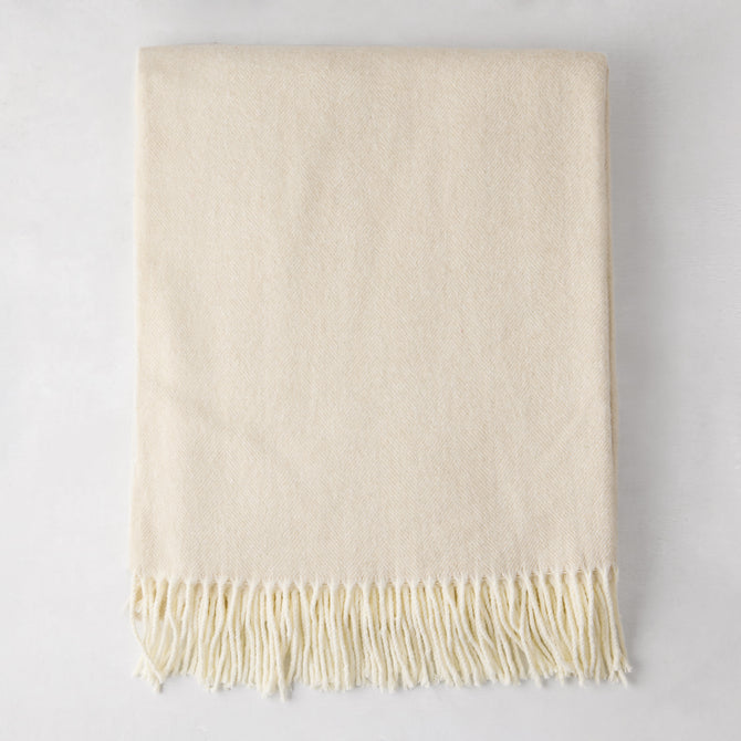 Birch off-white Italian herringbone throw blanket, folded, with fringe.