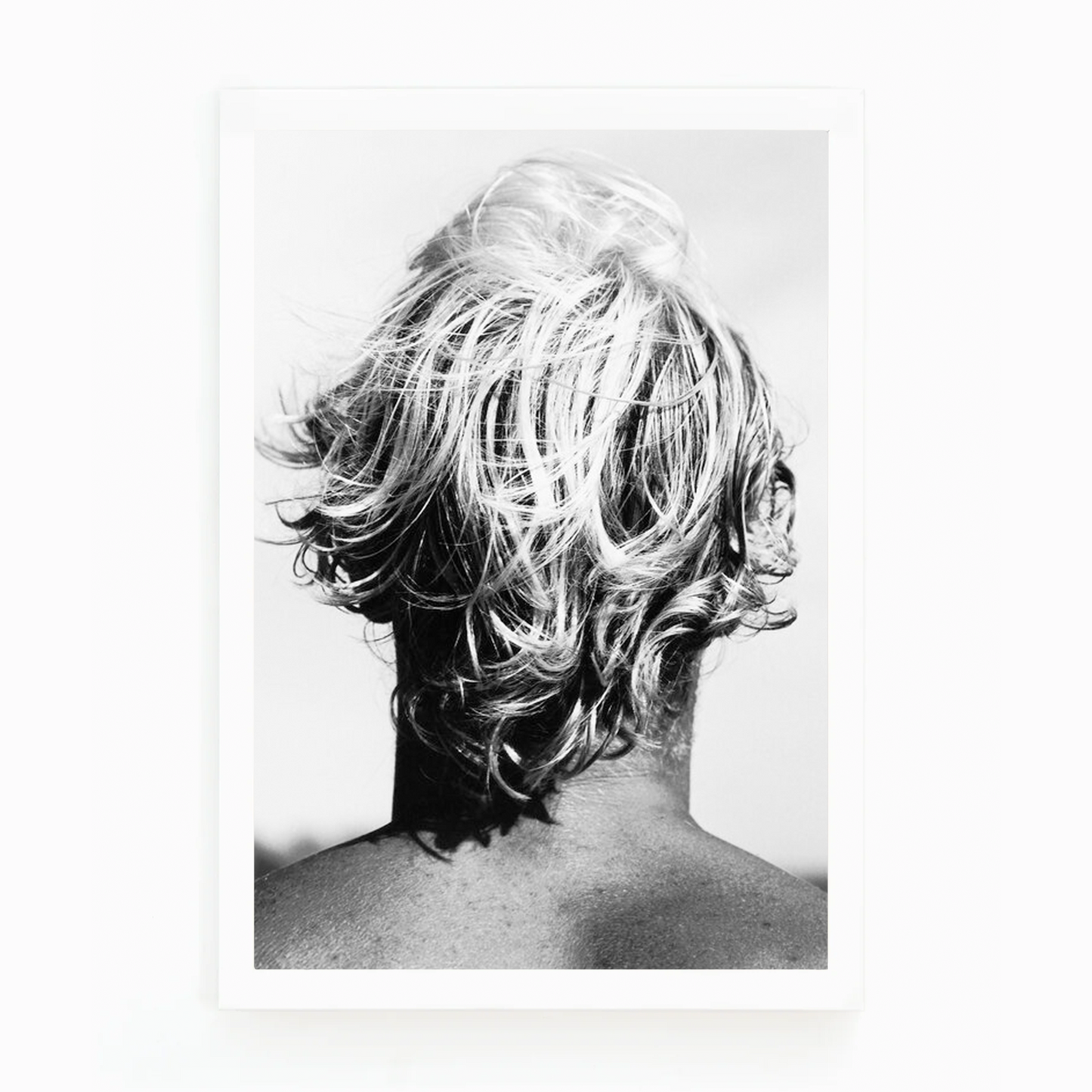 Black and white photograph by Matt Albiani showing the back of a surfer's head with messy, light hair.