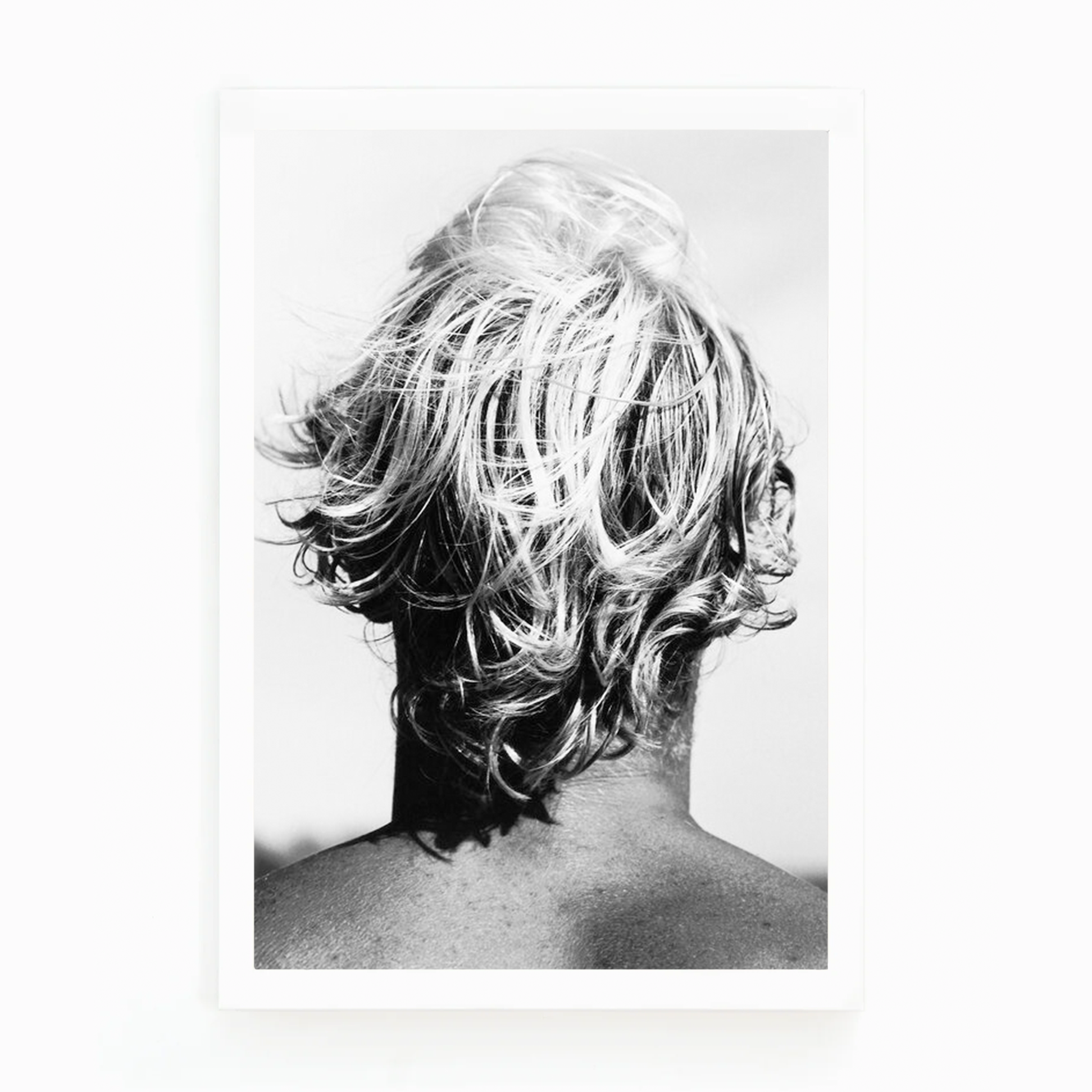 Black and white photograph by Matt Albiani showing the back of a surfer's head with messy, light hair.