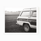 Black and white photograph of a vintage Wagoneer parked in a grassy field by Matt Albiani.