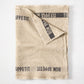 Khaki linen table runner with "Bon Appetit" printed in black, folded on a white surface.