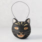Distressed black papier-mâché cat candy bucket with gold accents, white whiskers, and a wire handle.