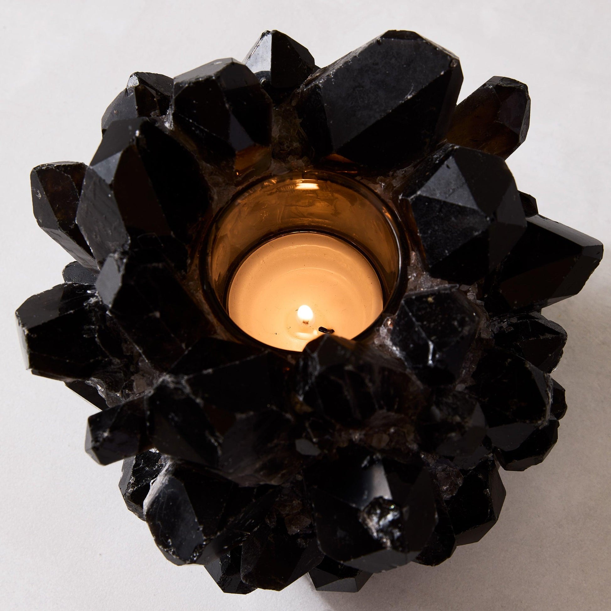 Black genuine quartz crystal votive candle holder with a lit candle, 6.5"Dia x 5.5"H.