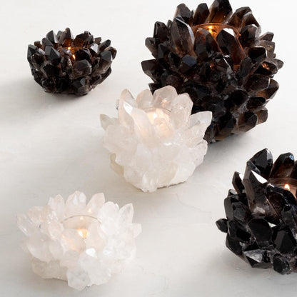 Four genuine quartz crystal votive candle holders, two black and two white, with lit candles.