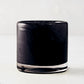 Mouth-blown black glass votive candle holder with a smooth, cylindrical design, 2.75 inches tall.