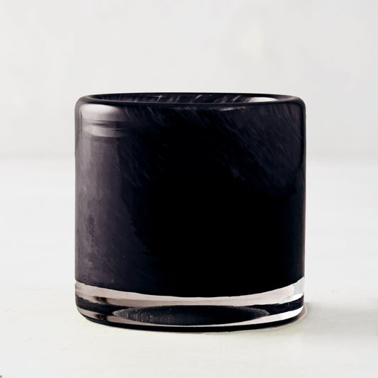 Mouth-blown black glass votive candle holder with a smooth, cylindrical design, 2.75 inches tall.