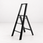 Black Hasegawa Lucano 3-step ladder in matte black aluminum and steel with a minimalist design and safety bar.