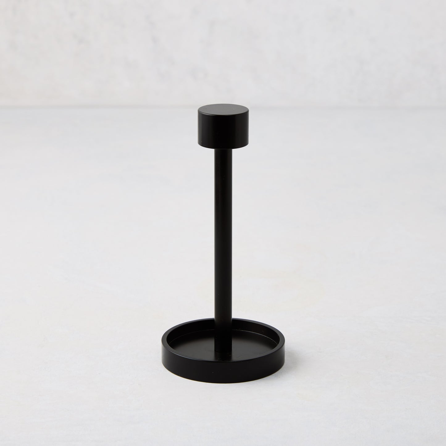 Black metal tear-off cocktail napkin holder, 5"H, with a round base and top.