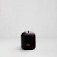 Hudson Grace black unscented pillar candle with gold HG logo and oversized cotton wick on a white background