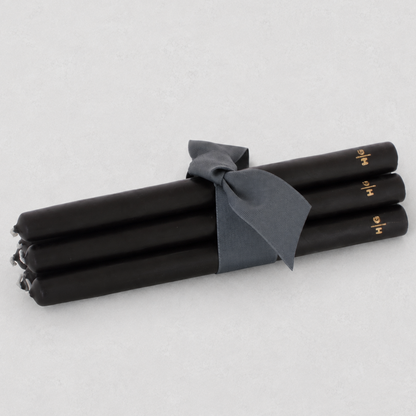 Three oversized 22-inch black taper candles tied with a grey ribbon, featuring a hand-embossed gold HG logo.