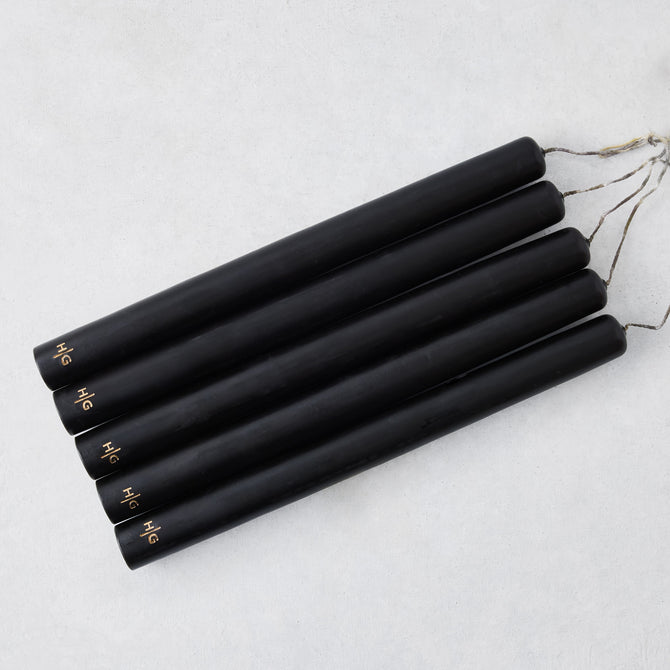 Set of five 10-inch black unscented taper candles with hand-embossed gold Hudson Grace logos on a white background.