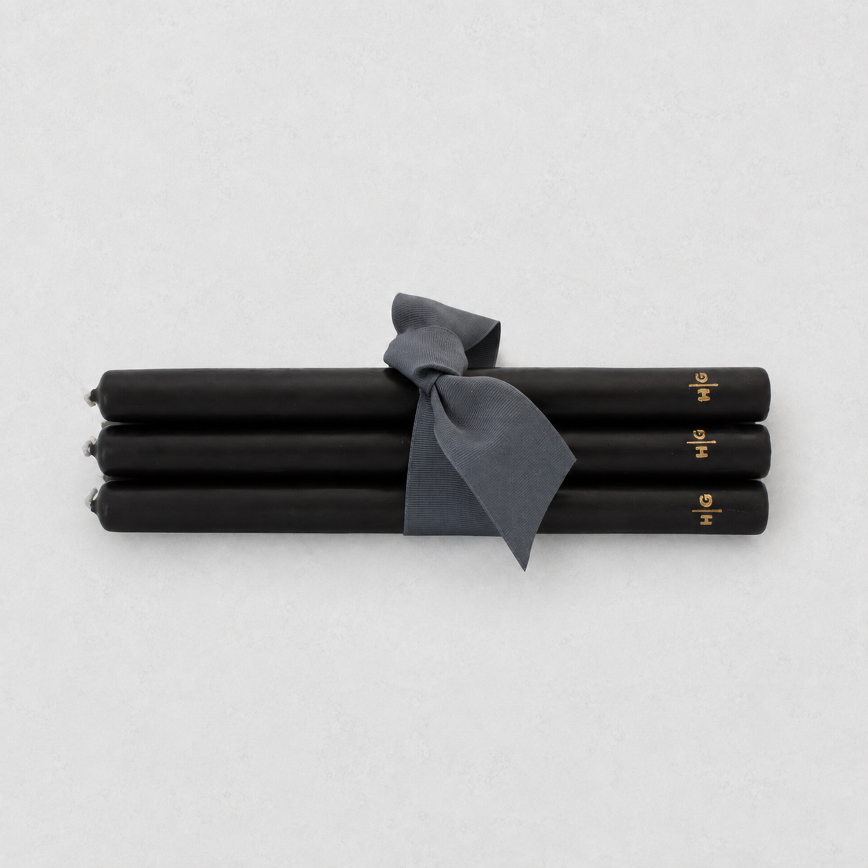 Set of five 10-inch black unscented taper candles tied with a grey ribbon, featuring a gold embossed Hudson Grace logo.