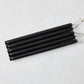 Set of five 15-inch black hand-dipped taper candles with gold HG logo and cotton wicks on a white background.