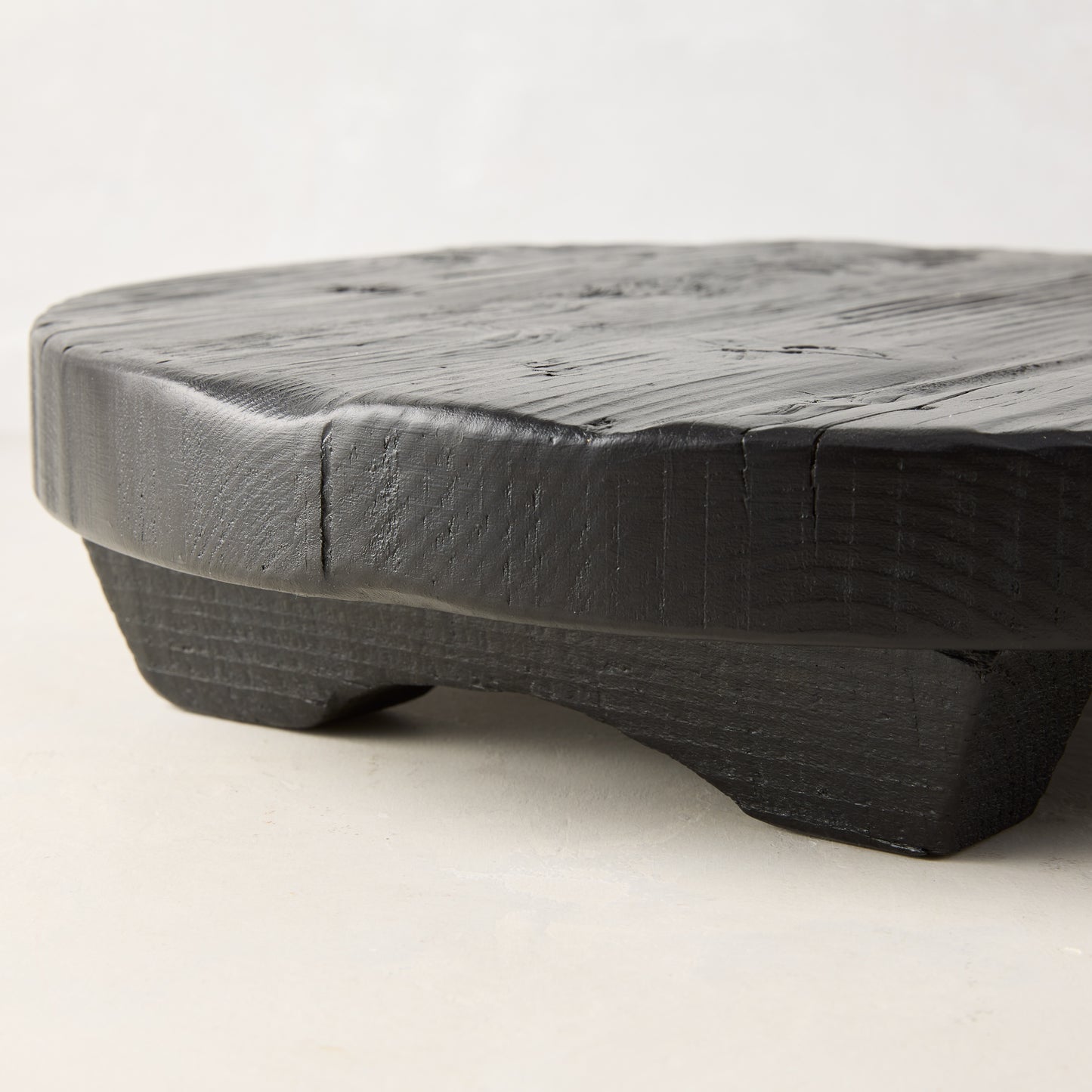 Black round footed serve board, hand-carved European pine, 19.7" diameter.