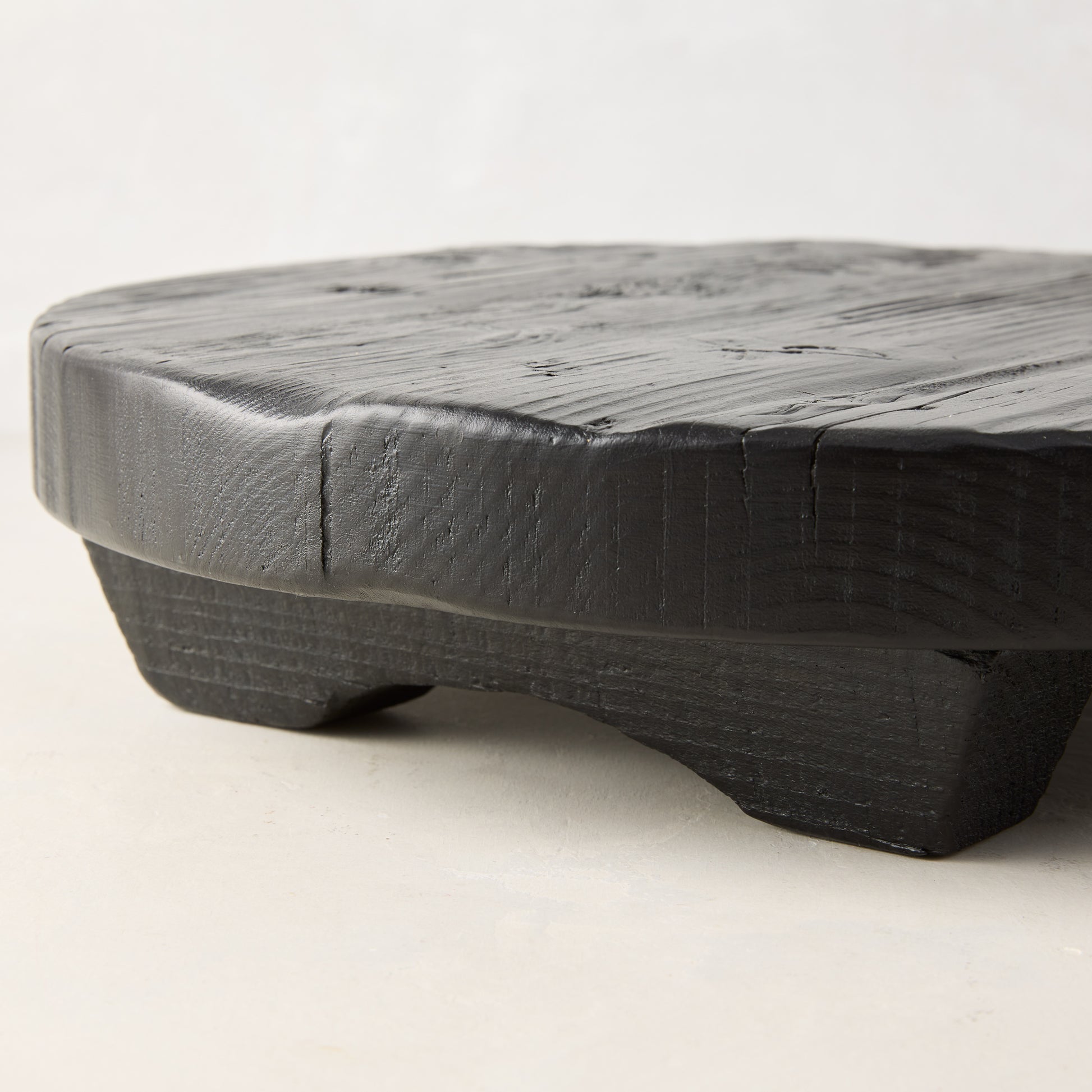 Black round footed serve board, hand-carved European pine, 19.7" diameter.