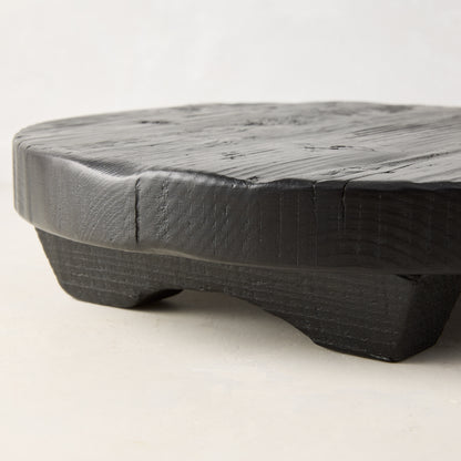 Black round footed serve board, hand-carved European pine, 19.7" diameter.