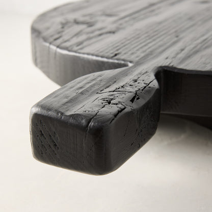 Black hand-carved round footed serve board with handle, made from distressed European pine wood.