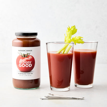 Hudson Grace "Bloody Good" Bloody Mary mix jar, two glasses with mix and celery, and silver cocktail picks.