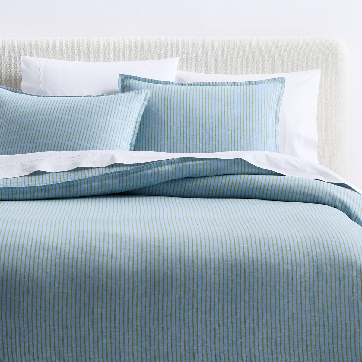 Blue and green striped European washed linen euro shams on a bed with matching duvet cover.