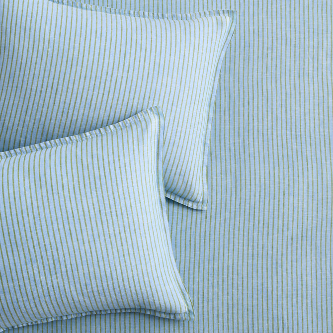Two blue and green striped European washed linen euro shams on matching striped bedding.